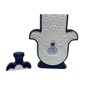 A Recycled Blanco Tequila Candle made from a white and blue Casa de Hamsa Tequila Blanco bottle shaped like a Hamsa hand, shown with its matching cap—perfect for upcycling into a unique candle.