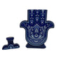 The Recycled Blanco Tequila Candle comes in a ceramic Hamsa hand bottle with a blue and white eye design and matching stopper, making it a unique holder for your favorite natural soy candle.