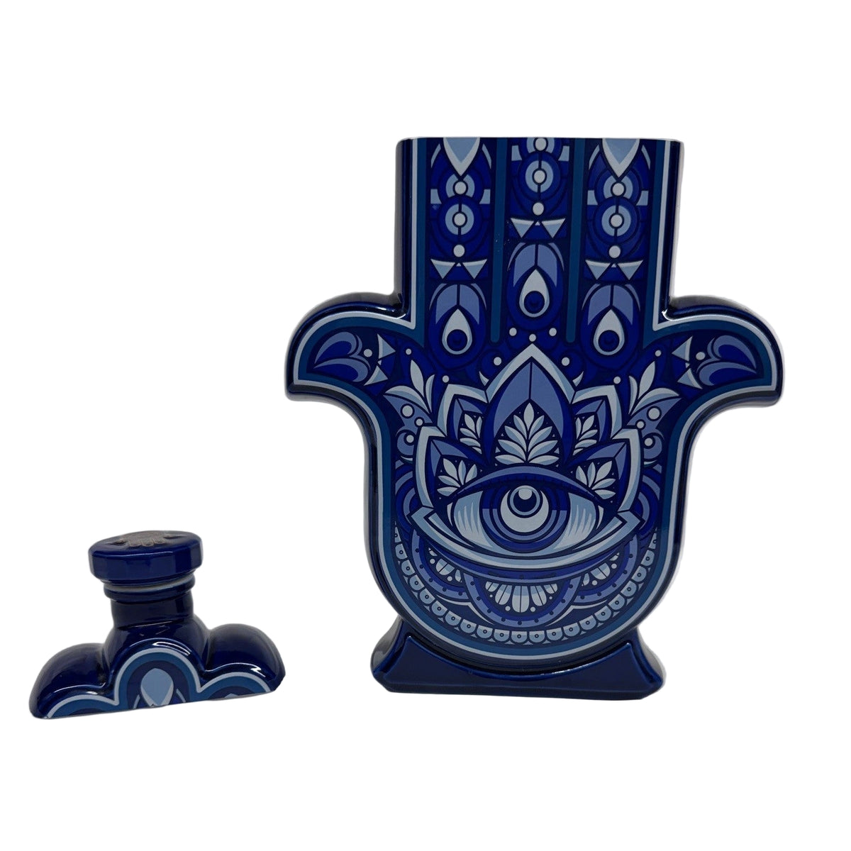 The Recycled Blanco Tequila Candle comes in a ceramic Hamsa hand bottle with a blue and white eye design and matching stopper, making it a unique holder for your favorite natural soy candle.