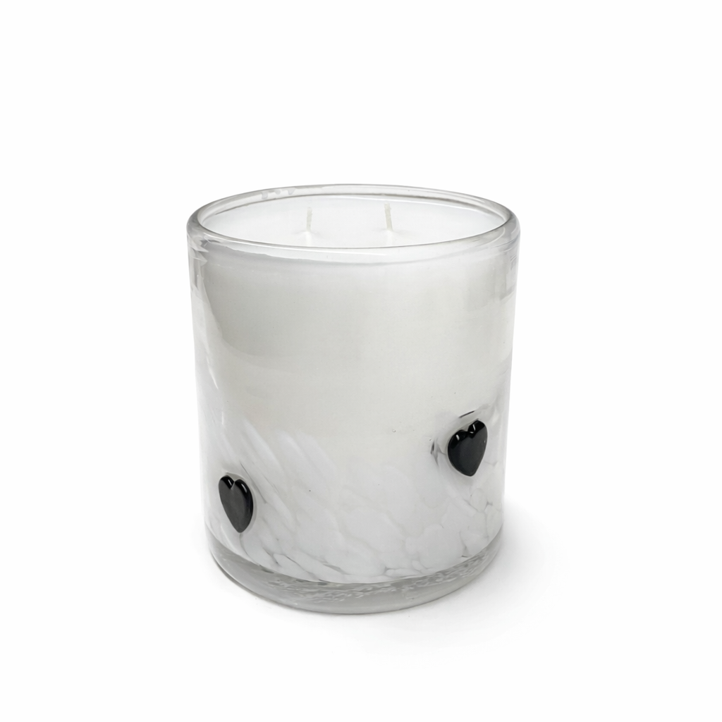 Clear glass candle with black heart-shaped wick holders on a white background