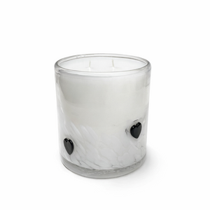 Clear glass candle with black heart-shaped wick holders on a white background