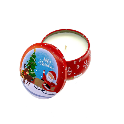 The Merry Christmas Holiday Tin Candle – Christmas Cookie Scent features a festive red tin with Santa, reindeer, and tree designs. The lid is slightly open to reveal the white candle inside.
