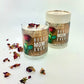 Best Mom Ever quoted candle with box – Amber Scent, presented in a glass jar and cylindrical box with a red rose design, surrounded by dried flower petals.