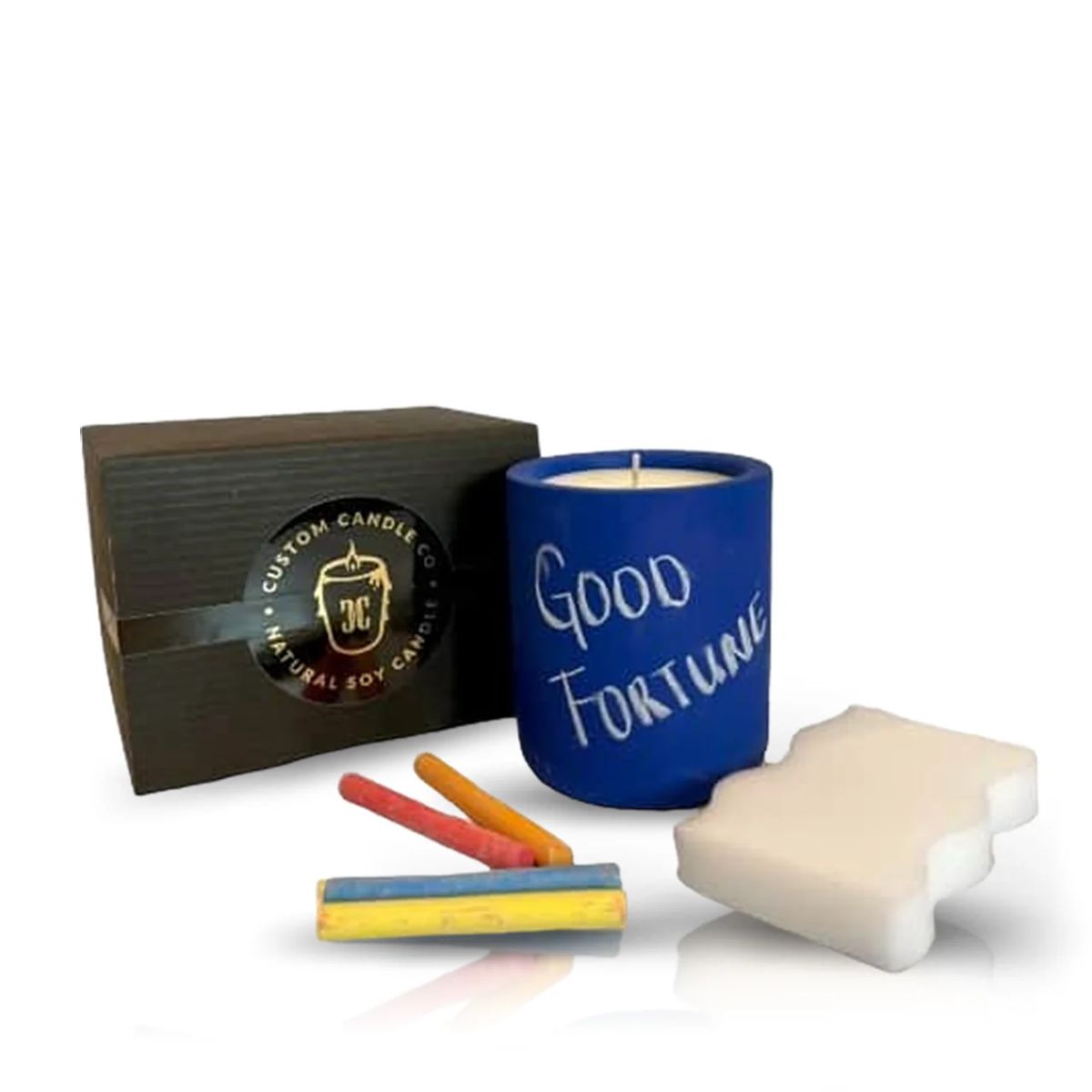 The Intention Blue Candle labeled "Good Fortune," three colored chalk pieces, a white eraser, and a branded brown box are displayed on a white background—ideal for spiritual rituals.
