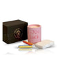An Intention Pink Candle labeled "GOOD LUCK," three colored chalk sticks, a white eraser, and a black box are arranged on a white background.