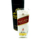 The Recycled Red Label Whiskey Candle is a white recycled candle in a glass holder shaped like a Johnnie Walker Red Label bottle, shown in front of a black cylindrical container.