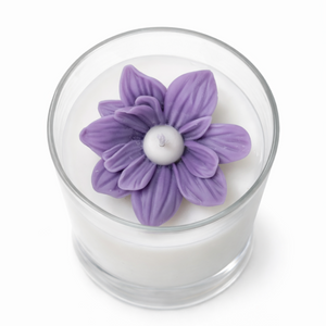 Candle with a purple flower-shaped candle top on a white background