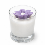 Candle with a purple flower-shaped wick on a white background