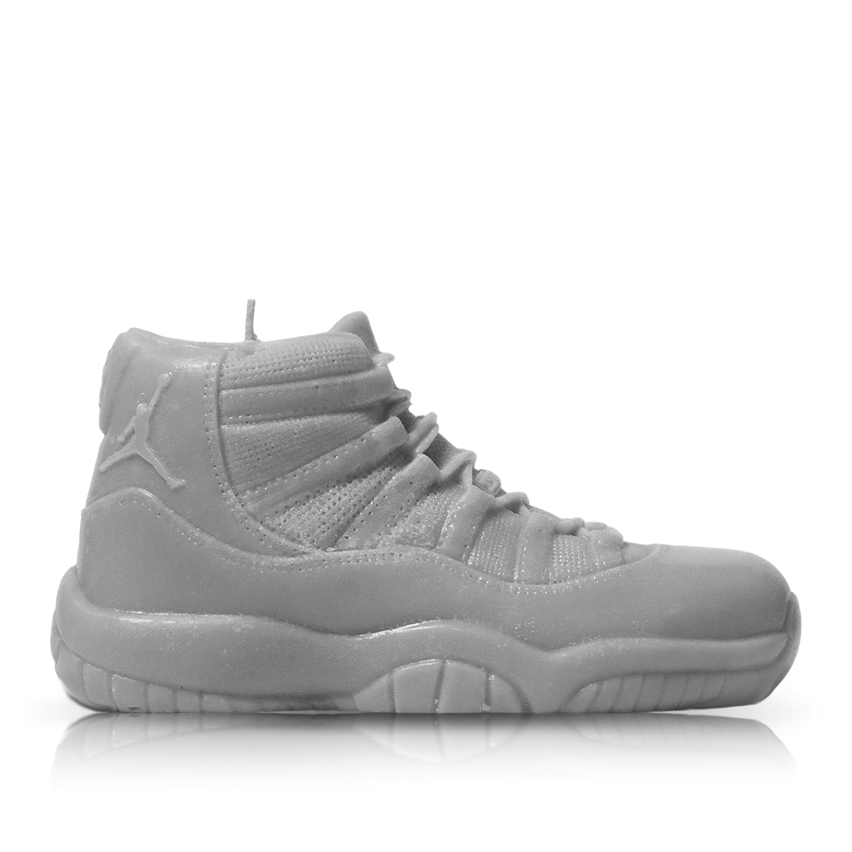 The Jordan 11 Medium Sneaker Candle (On Backorder) is a gray, hand-poured candle shaped like an athletic shoe, shown in profile against a plain white background.