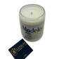 The Recycled Especial Beer Candle, hand poured in a glass made from a recycled Modelo Especial bottle, sits next to a black "3C Custom Candle Co." matchbox on a white background.