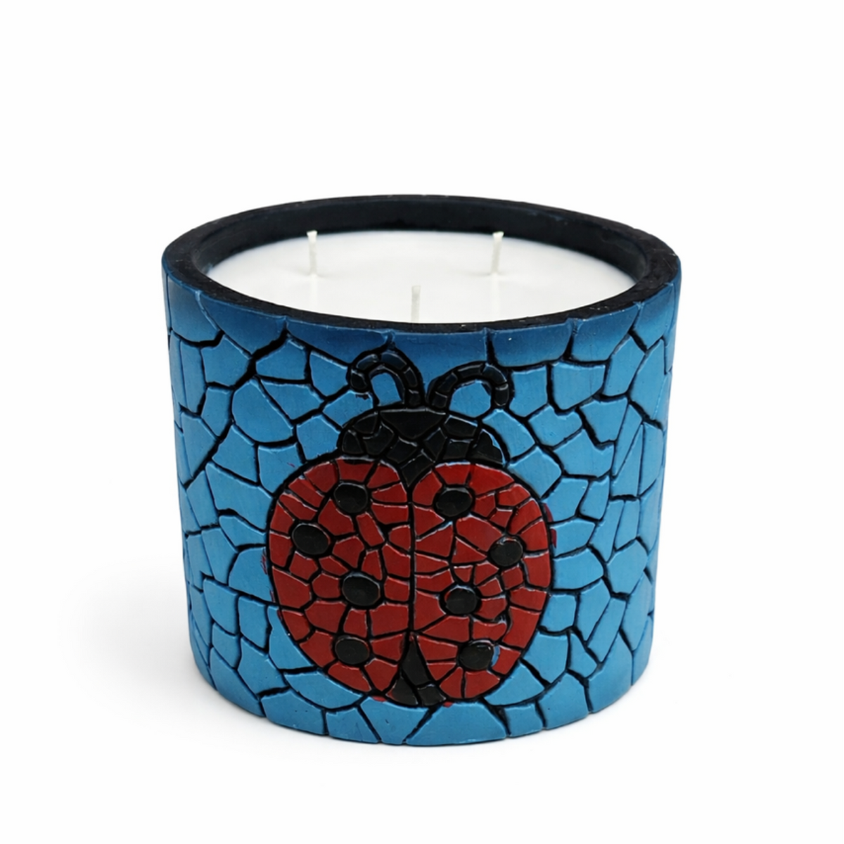 Candle in a blue mosaic holder with a ladybug design on a white background