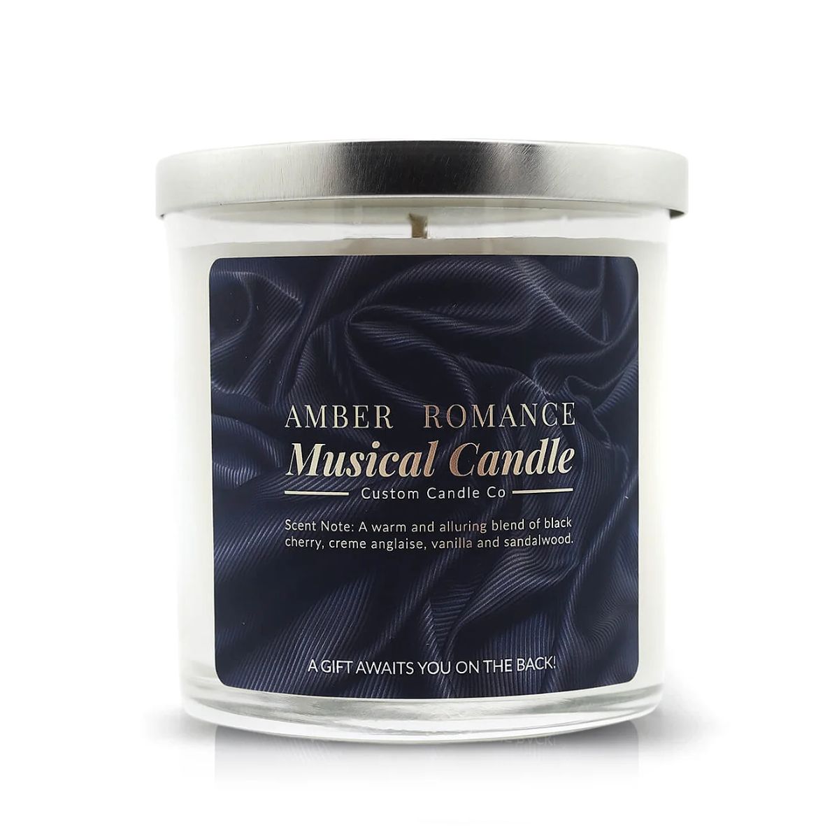 The Musical Love Candle – Amber Romance is a glass jar candle with a silver lid and dark blue label, offering black cherry, vanilla, and sandalwood scents—an ideal Valentine’s Day gift from the Musical Love Candles collection.