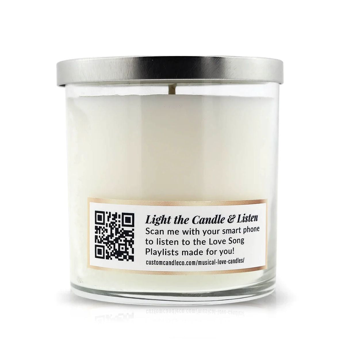 The Musical Love Candle – Amber Romance is a white scented candle in a glass jar with a silver lid, featuring a QR code on the label to scan for a love song playlist—ideal for Valentine’s Day and part of the Musical Love Candles collection.