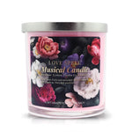 The Musical Love Candle – Love Spell is a pink scented candle in a glass jar with a silver lid, decorated with colorful flowers and labeled with fragrance and gifting details—an ideal Valentine’s Day gift.