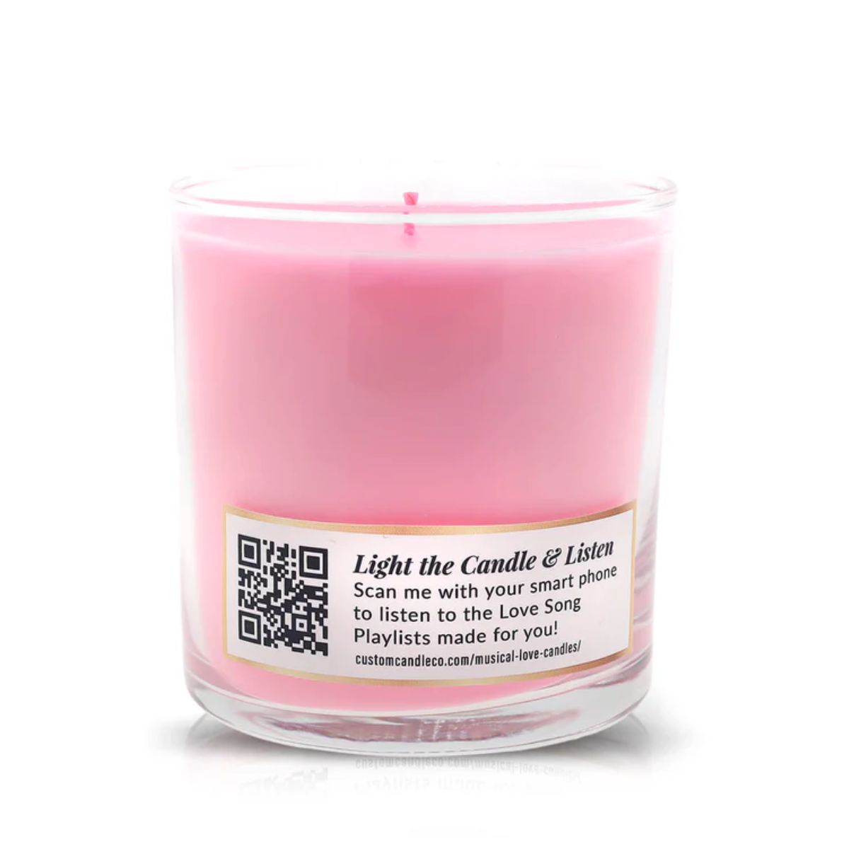 The Musical Love Candle – Love Spell is a pink scented candle in a clear glass jar with a label featuring a QR code that links to a love song playlist—perfect for Valentine’s Day or as part of our exclusive collection.