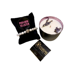 The Mother’s Day Gift Box includes a white bracelet on a black pillow with a "Push Here to Listen" button, a soothing lavender candle, and a business card for The Custom Candle Co.—a thoughtful gift for mom.