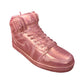 The AJ-1 Pink Shimmer Sneaker Candle (On Backorder) is a hand-poured, all-natural wax candle shaped like a pink high-top sneaker with laces and a swoosh, shown isolated on a white background.