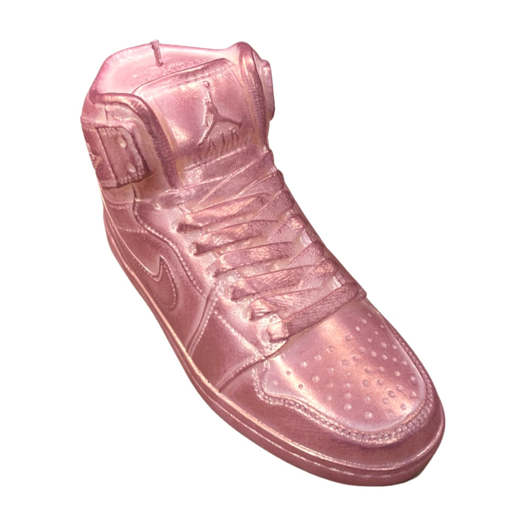 The AJ-1 Pink Shimmer Sneaker Candle (On Backorder) is a pink, translucent candle shaped like an Air Jordan sneaker, hand poured with all-natural wax and displayed on a white background.