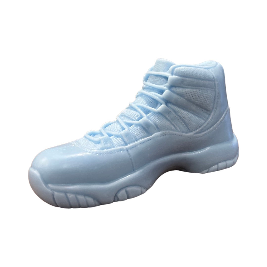 The AJ-11 Baby Blue Hightop Sneaker Candle – Large (On Backorder) is shown from the side, highlighting its hand-poured baby blue design with detailed laces and treads against a plain white background.