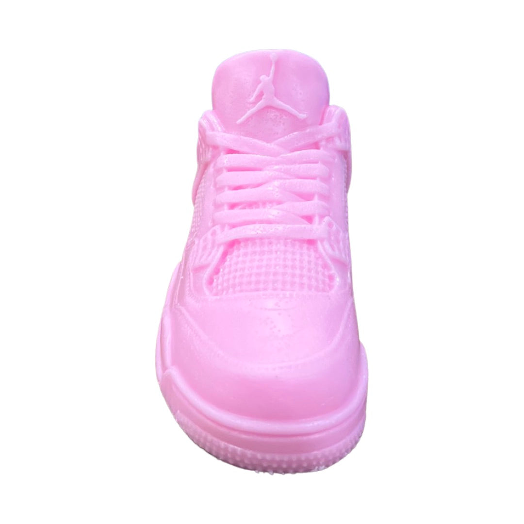 The AJ-4 Baby Pink Sneaker Candle – XL (On Backorder) is shaped like an Air Jordan, shown from the front against a white background, making it a unique decorative piece.