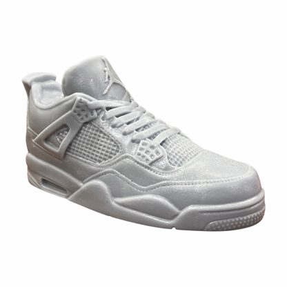 The AJ-4 Gray Sneaker Candle – XL (On Backorder) is a monochromatic light gray candle, styled after the Air Jordan 4, shown in profile on a white background, hand poured with a subtle Black Ice scent.