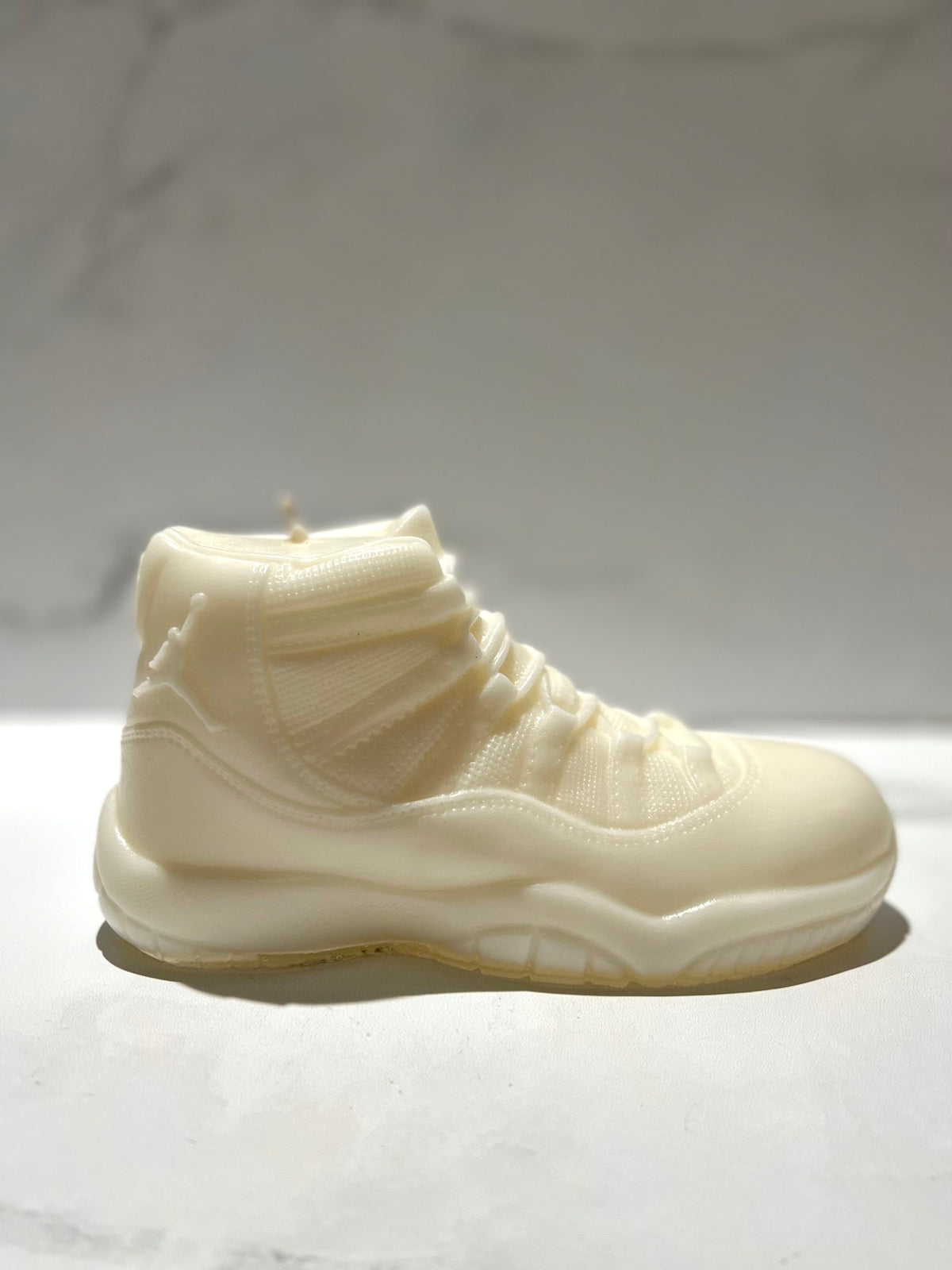The AJ-11 White Hightop Sneaker Candle – Large features a hand-poured design resembling a white sports shoe, combining quality and style; currently on backorder.