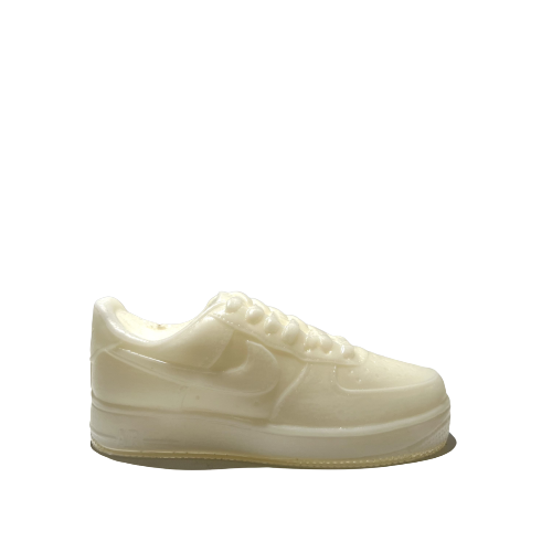 The AF1 – White Lowtop Sneaker Candle – Large (On Backorder), a cream-colored translucent candle shaped like a white lowtop sneaker, is shown against a plain light gray background.