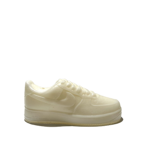 The AF1 – White Lowtop Sneaker Candle – Large (On Backorder), a cream-colored translucent candle shaped like a white lowtop sneaker, is shown against a plain light gray background.
