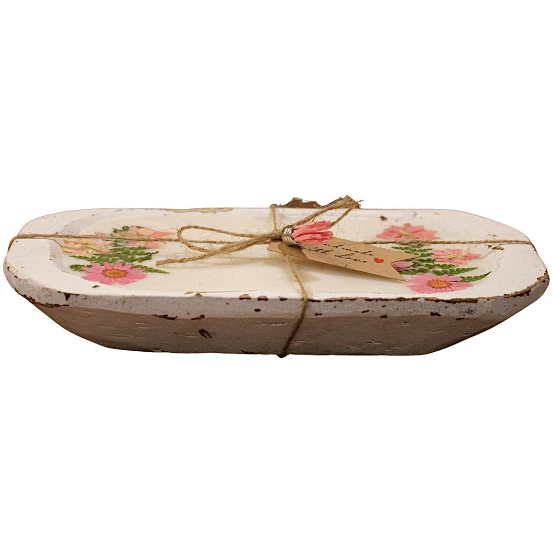 The Pink Floral Wood Candle—Floral Scented—features a whitewashed wooden tray with pink floral designs, distressed edges, and a twine bow with a brown tag, making it a charming rustic centerpiece for your home.
