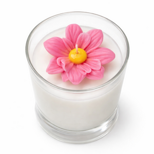 Candle in a glass jar with a pink flower on top against a white background