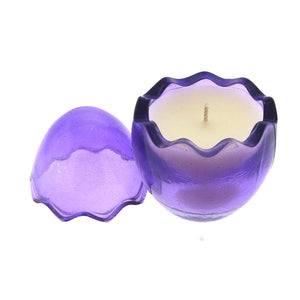 The Purple Glass Easter Egg features a wavy-edged, egg-shaped purple candle holder with a white natural wax candle inside and its matching lid placed beside it.