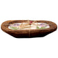 A rustic wooden bowl holds the Purple Floral Wood Candle – Floral Scented, crafted with coconut-apricot wax, adorned with pressed purple flowers and green ferns, and finished with twine and a small tag.