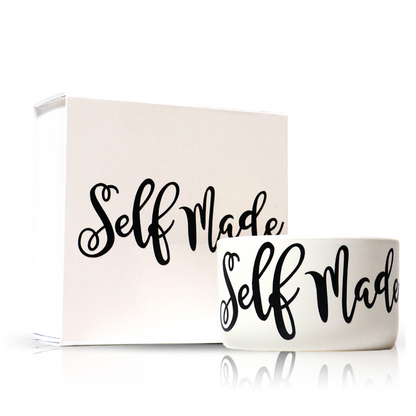 The "Self Made" White Candle Gift Box Set includes a natural wax candle and a white ceramic mug, both featuring "Self Made" in bold black script—a thoughtful, inspiring gift for any occasion.