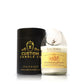 The Recycled Cognac Candle, made with coconut-apricot wax and set in a white recycled cognac bottle, is placed next to a black Custom Candle Co. container, highlighting the brand and its unique cognac bottle candle design.