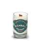 The Recycled Bourbon Whiskey Candle from Cooperstown Distillery is crafted from an upcycled whiskey bottle, features white wax, and includes a wooden wick.