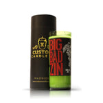 A Recycled Californian Wine Candle in a green glass wine bottle labeled "BIG BAD ZIN" sits beside a black Custom Candle Co. container with gold accents, highlighting the stylish appeal of upcycled bottle candles.