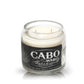 The Recycled Azul Agave Tequila Candle is a white soy candle in a clear glass with a black label reading "Cabo Wabo Tequila Blanco, 100% Agave Azul." Ideal for fans of unique tequila-inspired decor.
