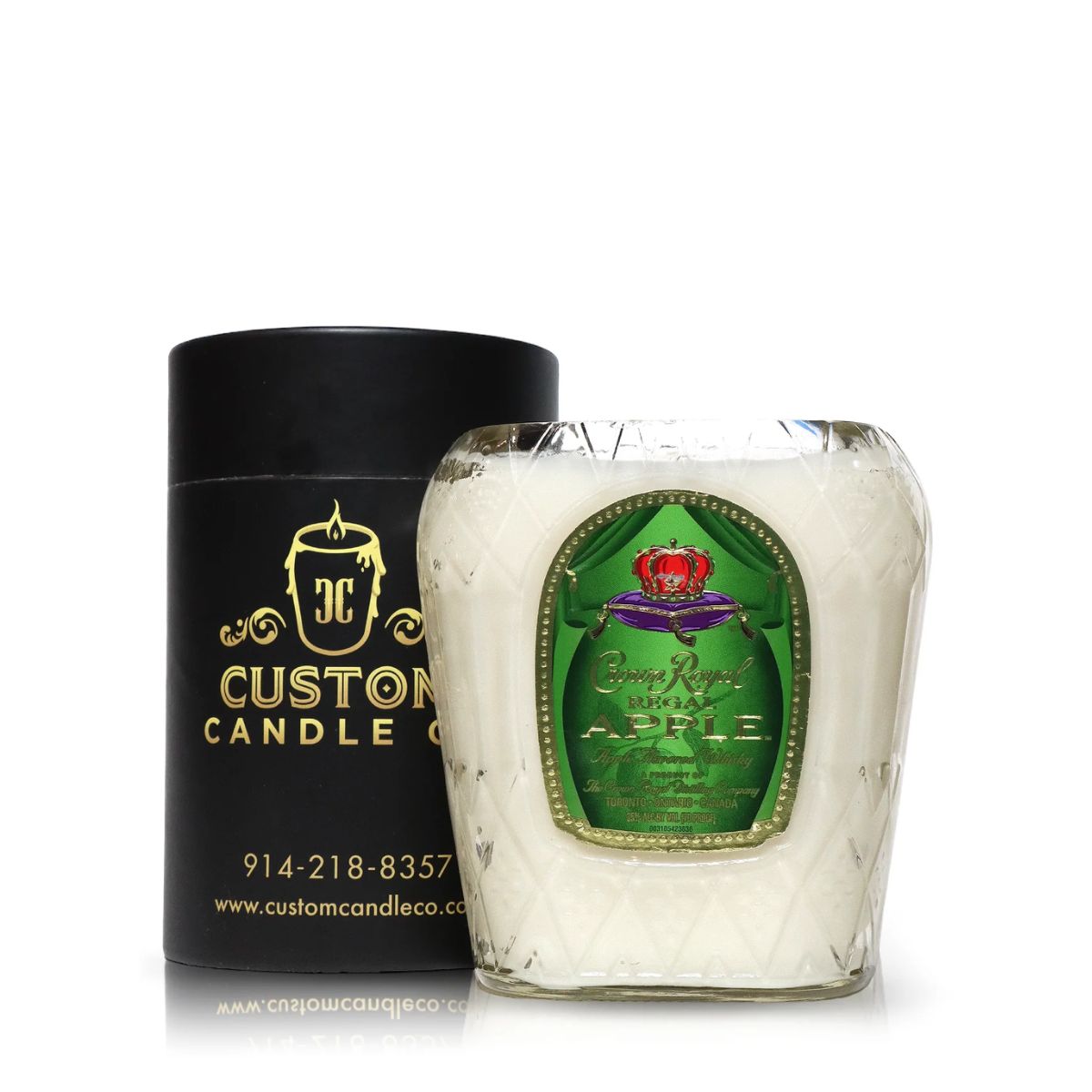 The Recycled Apple Whiskey Candle by Custom Candle Co. features coconut apricot wax in a glass container with a green Apple label, shown beside its sleek black cylindrical packaging.