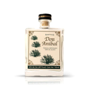 The Recycled Reserva Reposado Tequila Candle comes in a square Don Anibal tequila bottle with a cream label, agave illustrations, and gold accents. This unique candle is made from a 750ml bottle originally at 40% ABV.