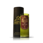 A Recycled Cabernet Wine Candle in a green glass upcycled wine bottle labeled "Don Tony Perez 2018 Cabernet Sauvignon" stands next to a black cylindrical Custom Candle box.