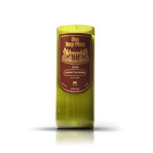The Recycled Cabernet Wine Candle is made from an upcycled wine bottle with a brown and gold "Don Tony Perez 2018 Cabernet Sauvignon, Curicó Valley" label, blending eco-friendly style and artisanal craftsmanship.