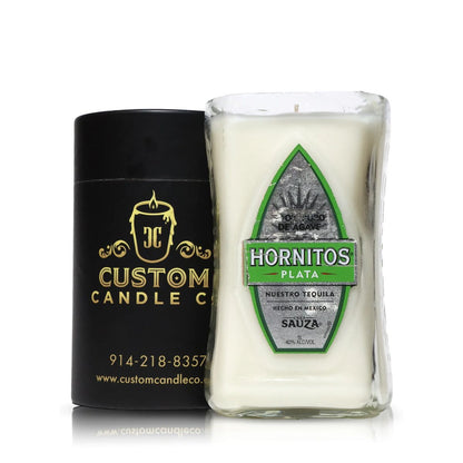 The Recycled Nuestro Tequila Candle, made from a repurposed Hornitos Plata tequila bottle, sits next to a black Custom Candle Co. box, showcasing unique candles crafted from recycled materials.