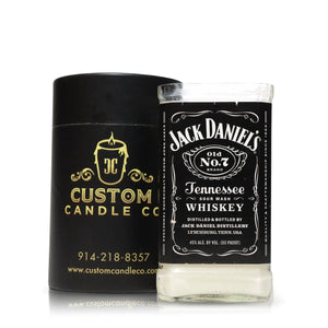 The Recycled Sour Mash Whiskey Candle, featuring coconut-apricot wax for a premium burn, is displayed in a "Jack Daniel's Tennessee Whiskey" glass beside a black "Custom Candle Co." box with branding and contact info.