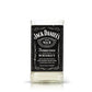 The Recycled Sour Mash Whiskey Candle is crafted from a clear glass featuring the iconic black-and-white Jack Daniel’s Old No. 7 label, upcycled into a candle with coconut-apricot wax and a small amount of liquid at the base.