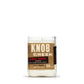 The Recycled Single Barrel Whiskey Candle is a white candle in a glass jar made from upcycled whiskey bottles, labeled "Knob Creek Single Barrel Reserve, Kentucky Straight Bourbon Whiskey, 120 proof.