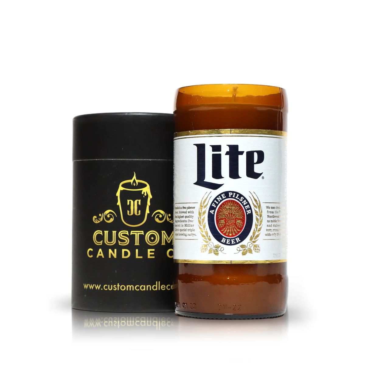 A Recycled Pilsner Beer Candle, hand poured in a repurposed Miller Lite bottle, sits next to a black Custom Candle Co. container with gold logo on a crisp white background.