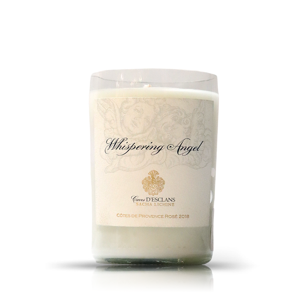 The Recycled 2018 Rosé Wine Candle is a white candle in a clear glass holder made from an upcycled wine bottle, featuring a "Whispering Angel" label with gold accents and Côtes de Provence Rosé 2018 text.