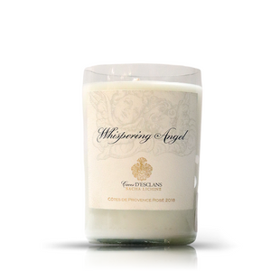 The Recycled 2018 Rosé Wine Candle is a white candle in a clear glass holder made from an upcycled wine bottle, featuring a "Whispering Angel" label with gold accents and Côtes de Provence Rosé 2018 text.