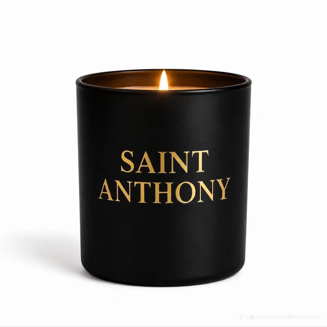 Black candle with 'Saint Anthony' in gold text on a white background, featuring the brand 'customcandlecoins'.