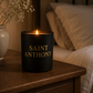 Black candle labeled 'Saint Anthony' on a wooden surface with a blurred background